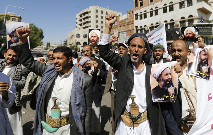 Shi'ite protesters shout slogans as they hold posters of Sheikh Nimr al-Nimr during a demonstration outside the Saudi embassy in Sanaa
